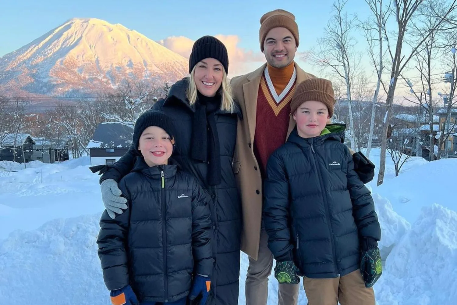 jules and guy sebastian with their two sons while standing in the snow on a holiday
