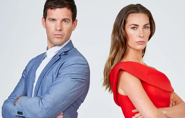 Two individuals standing back-to-back, wearing formal attire, with serious expressions.