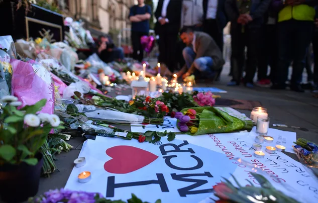 Candlelit vigil with flowers and tributes in Manchester, commemorating victims of the concert tragedy.