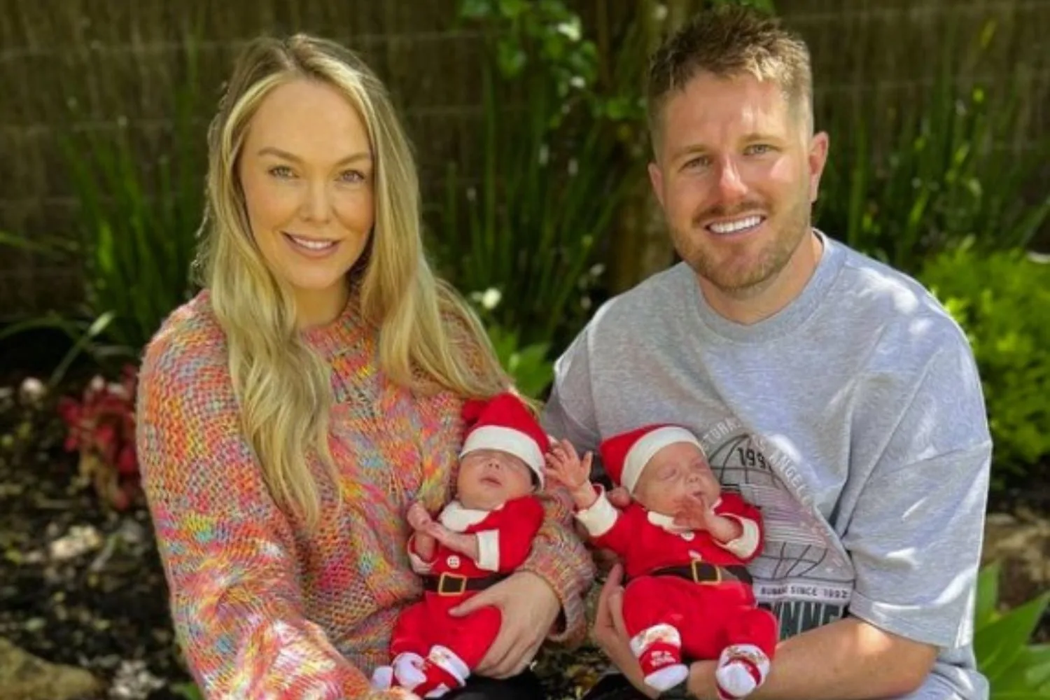 melissa rawson and bryce ruthven hold their newborn babies levi and tate as they are dressed in christmas pyjamas