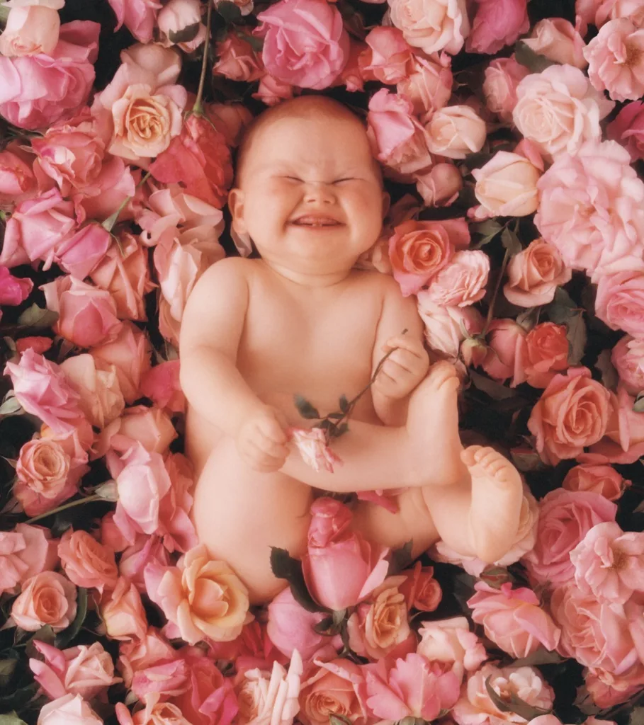 Anne Geddes photo of naked baby lying in roses