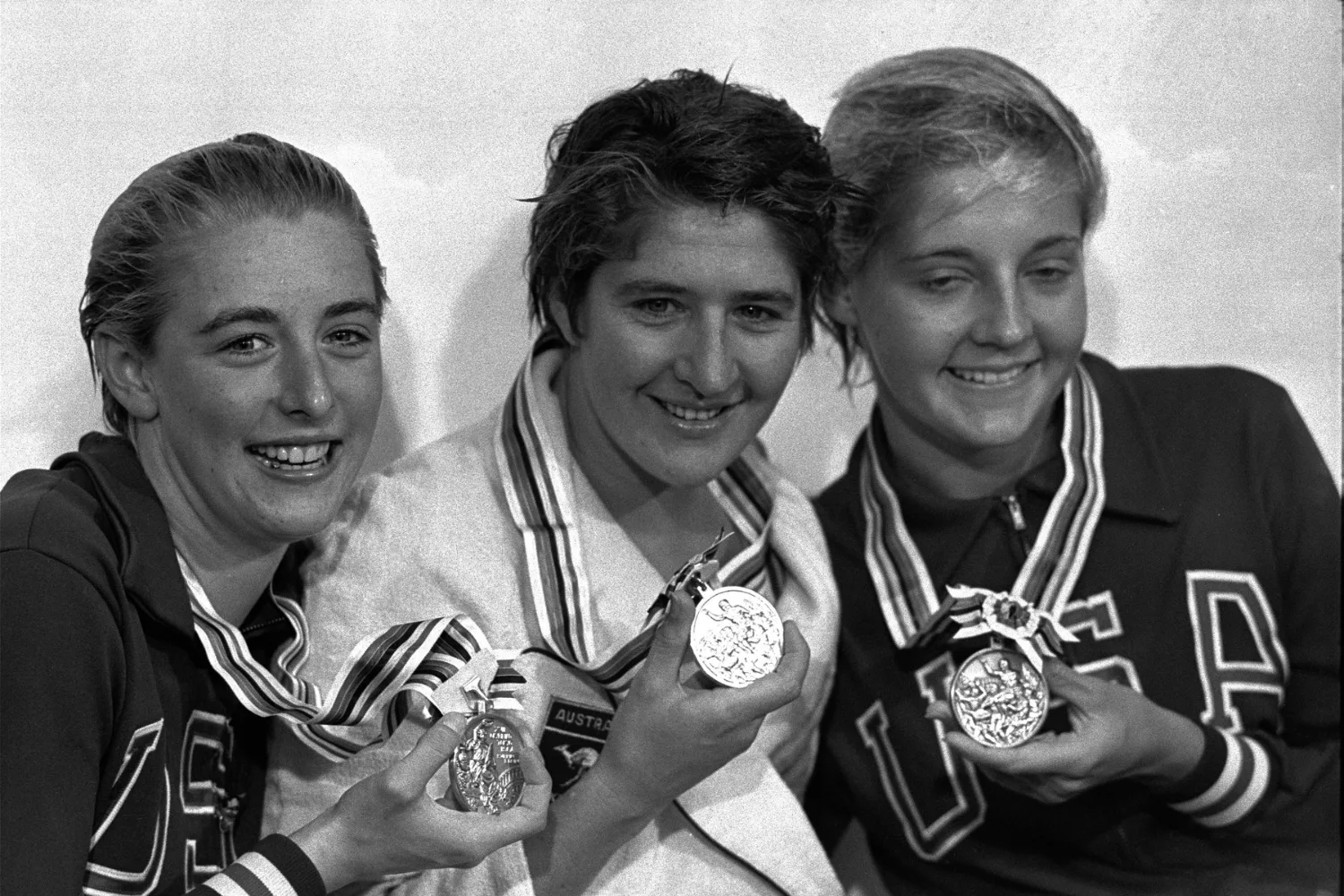 Dawn Fraser holding her gold medal, with Sharon Stouder holding her silver medal to her left, and Kathy Ellis with her bronze medal to her right.