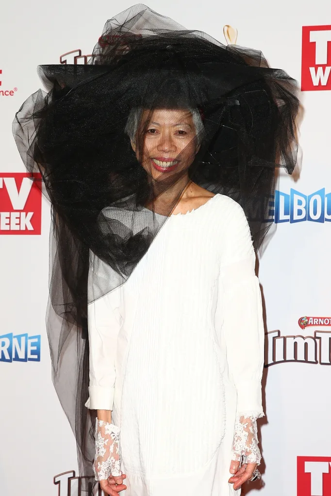 Lee Lin Chin wearing a white dress with black headpiece on the red carpet.