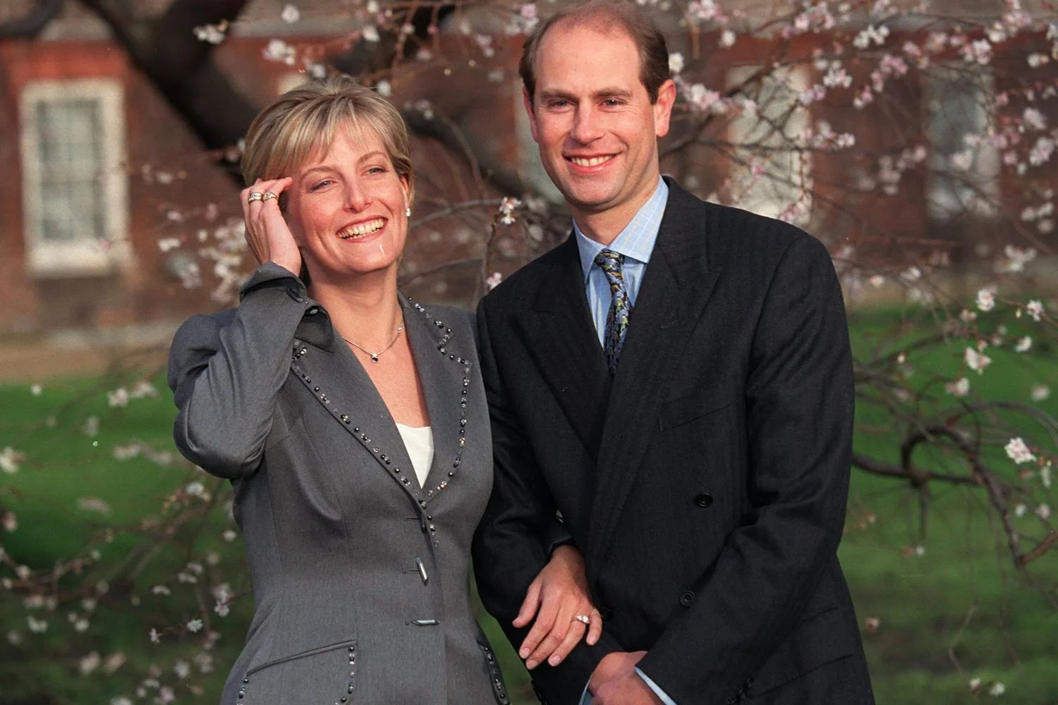 prince edward and sophie countess of wessex engagement announcement. prince edward in black blazer, blue blouse and tie. sophie countess of wessex wearing a grey blazer and white shirt.