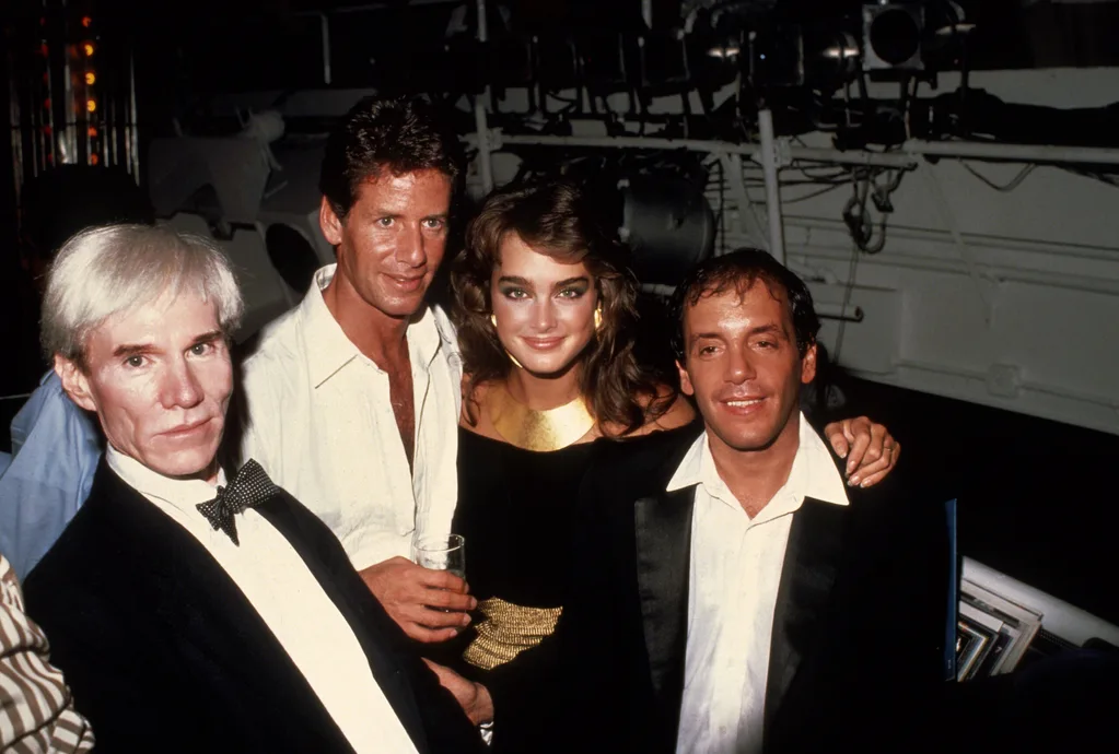 Andy Warhol, Calvin Klein, and Brooke Shields join Steve Rubell in the DJ booth, New York, New York,