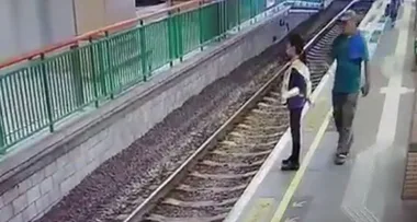 Horrifying moment woman is pushed onto train tracks by a stranger