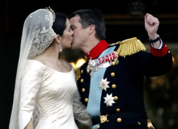 Crown Prince Frederik appears to pump his fist in delight during his smooch with new wife Mary