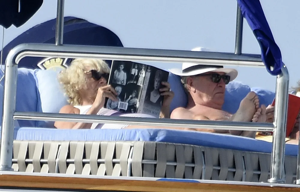 Stepping out in an array of brightly coloured bathing suits, Camilla looked relaxed as she soaked up the sun with a male companion.