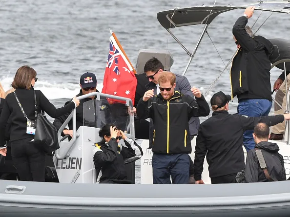 Caring Prince Harry has been captured on camera holding his pregnant wife Meghan Markle - now the Duchess of Sussex - steady on board a boat in Sydney on Oct. 21.