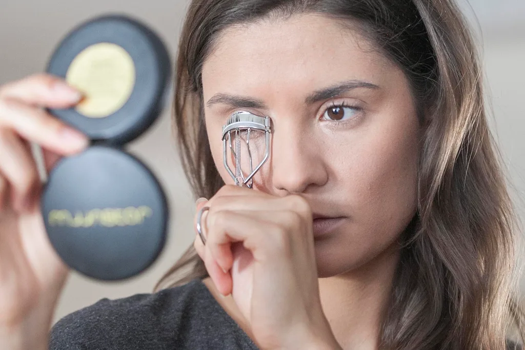 Woman using eyelash curler