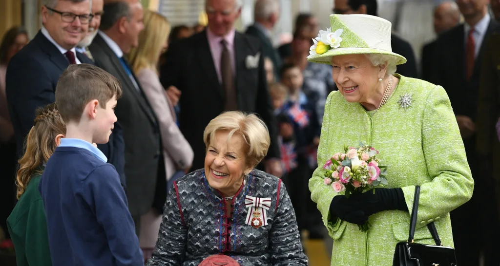 The Queen was greeted by Sam Henderson, Poppy Shaw (left, hidden) and the Lord Lieutenant of Somerset, Annie Maw