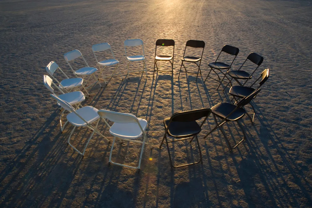 Set of chairs sitting in circle on sand
