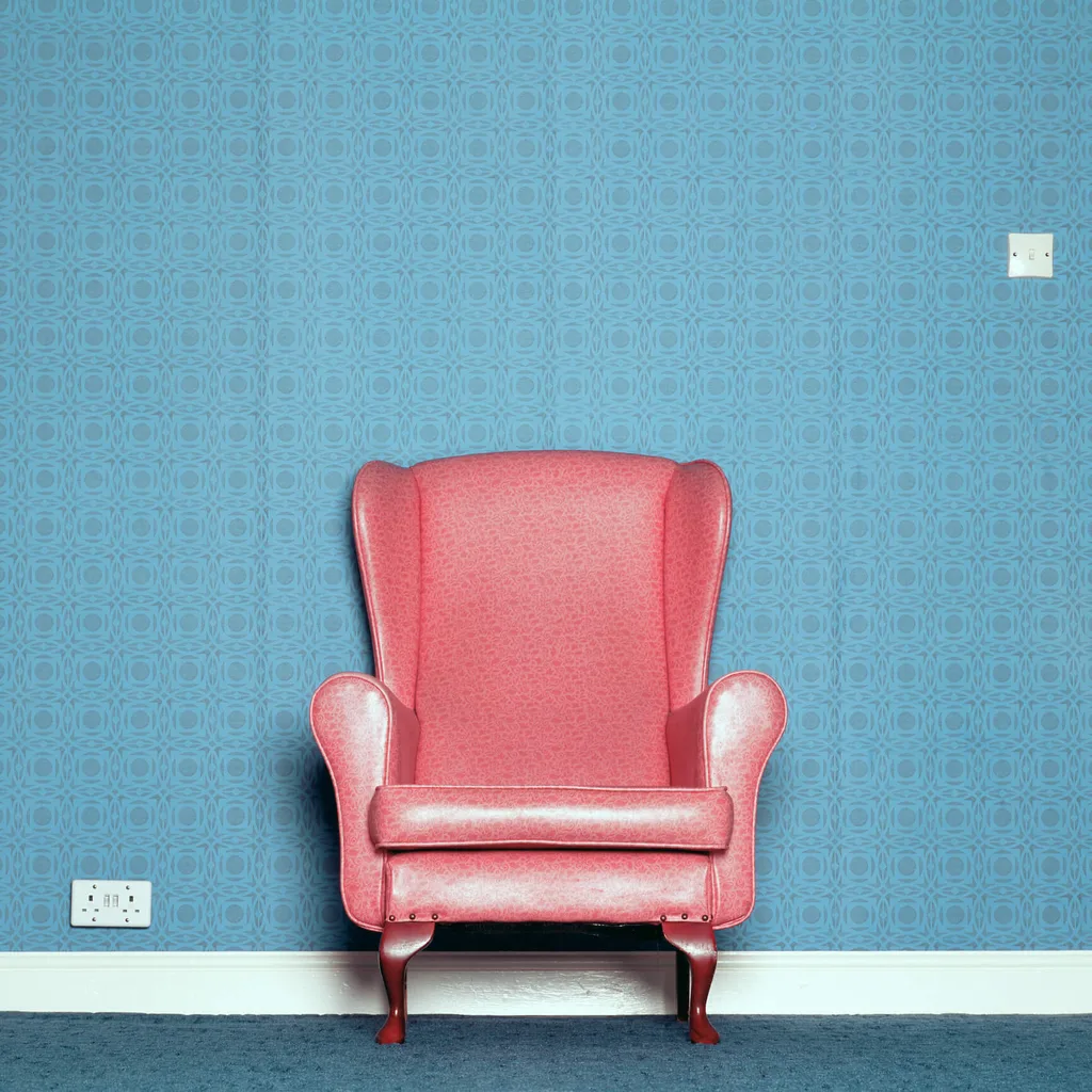 Retro pink chair with blue wallpaper