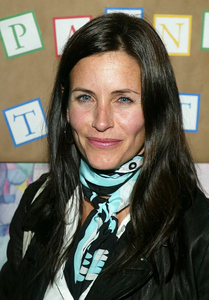 Courteney Cox wearing a black and blue scarf