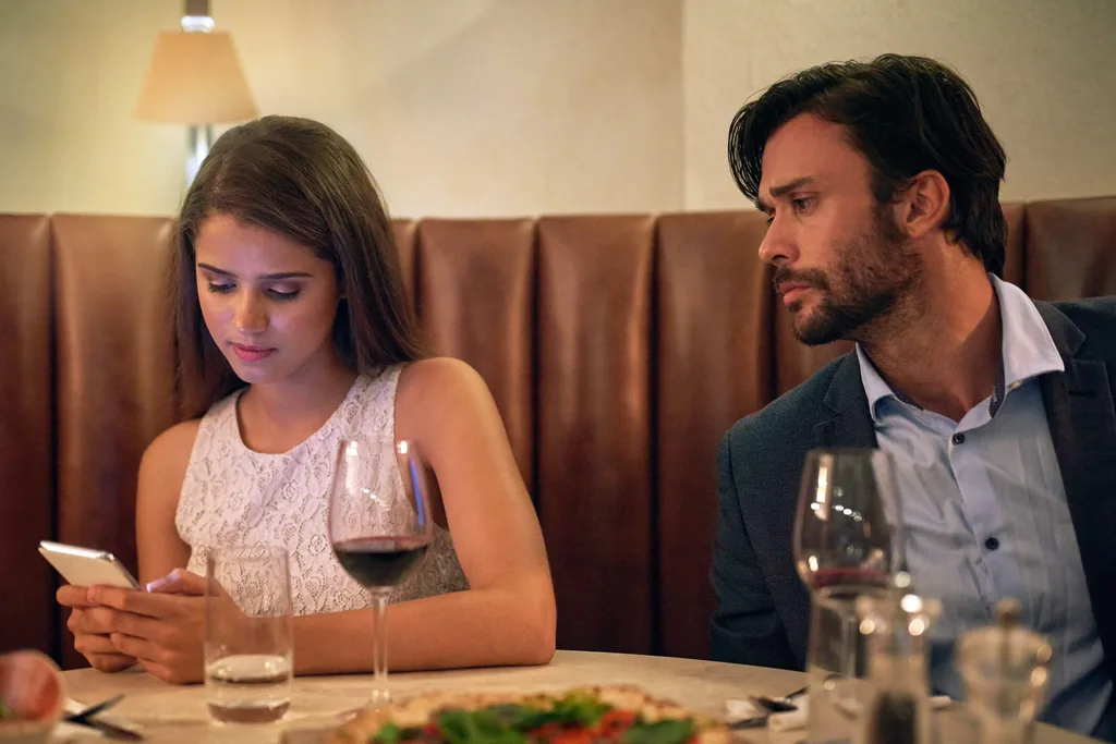 Guy looking at girl's phone on date