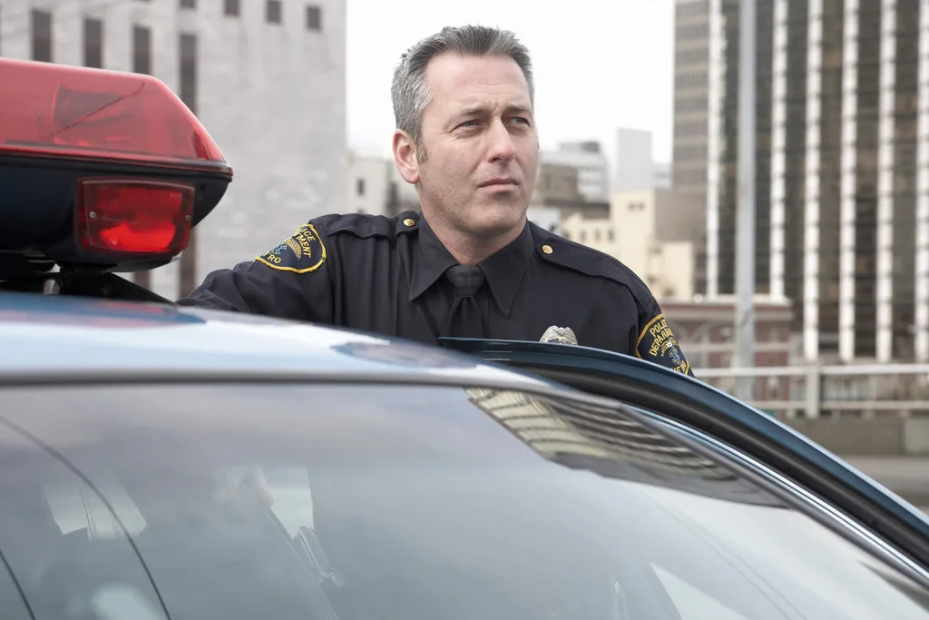 A police offer looking over a cop car