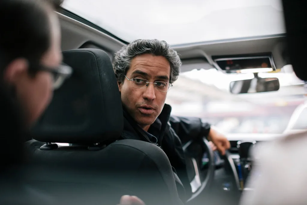 A taxi driver talking to a passenger