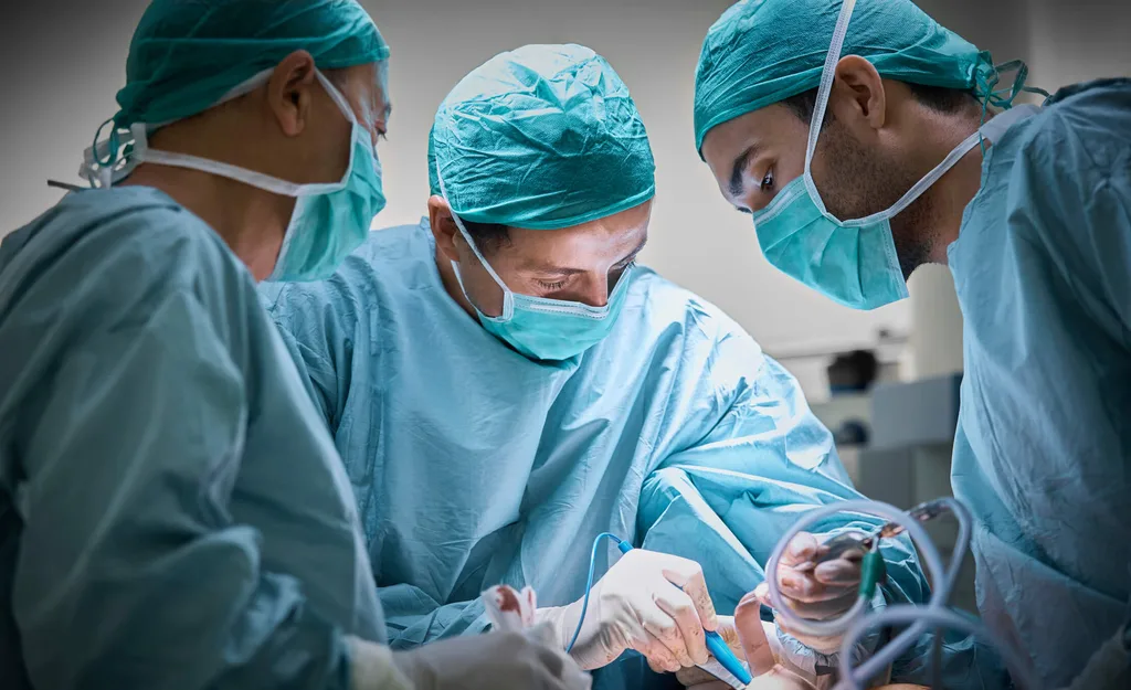 Three surgeons operating on a patient