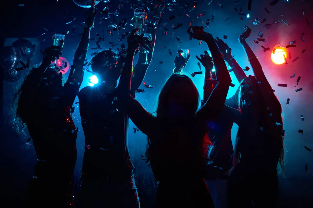 People dancing in a club lit by blue and pink light