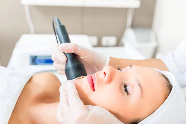 Woman getting IPL hair removal treatment from skin specialist