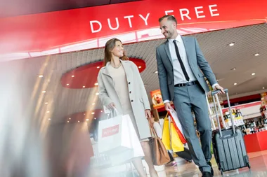 Two people leaving the 'Duty Free' section of the airport