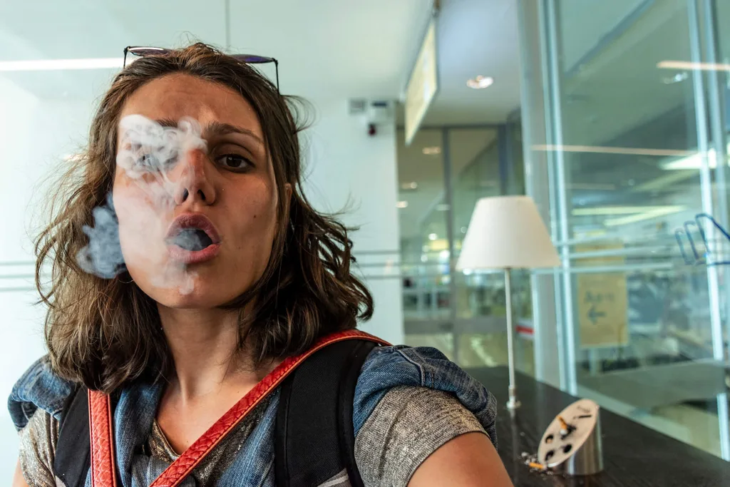 A woman smoking in a smoking-zone in an airport