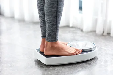 Woman wearing activewear standing on a scale