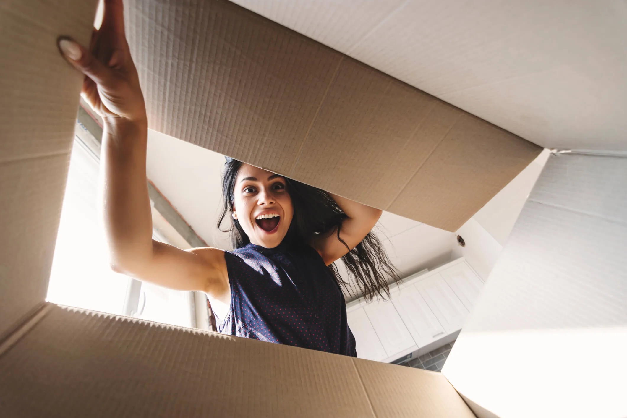 Woman excitedly opening cardboard box