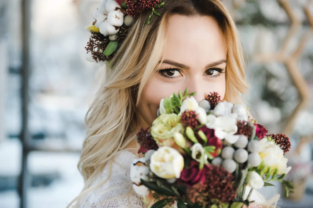 A boho themed bride holding a bunch of flowers