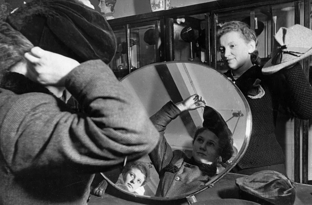 Russian woman trying on hat in Moscow department store, 1930