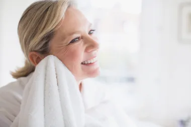 Woman drying her face with a white towel