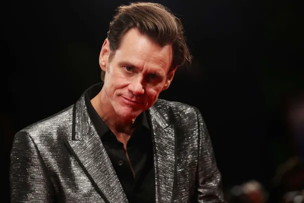 Portrait of Jim Carey swearing a silver suit against black background