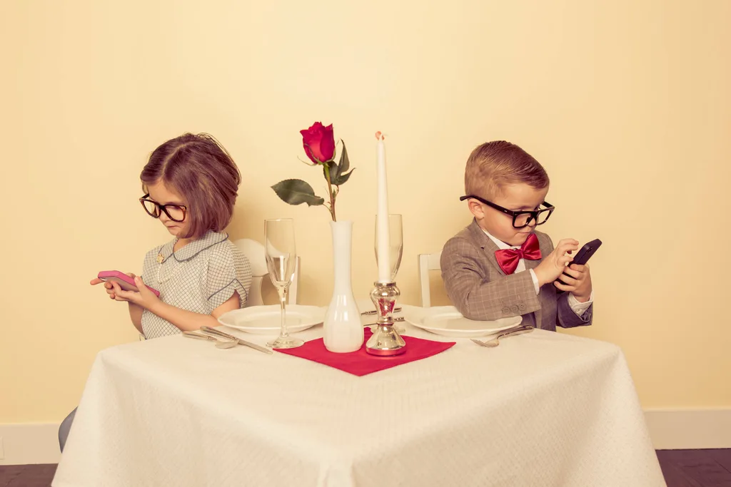 Two children on their phone while on a date