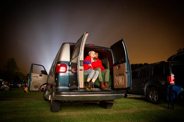 Two people in back of car at drive-in cinema