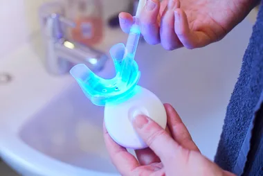 A person injecting a teeth whitening kit with whitening solution