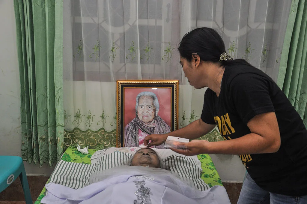 An Indonesian women applying makeup on the late Maria Tulak's face