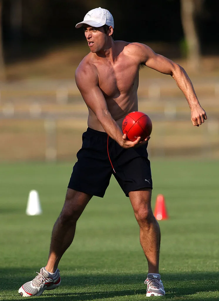 AFL player Simon Black, handballing a football