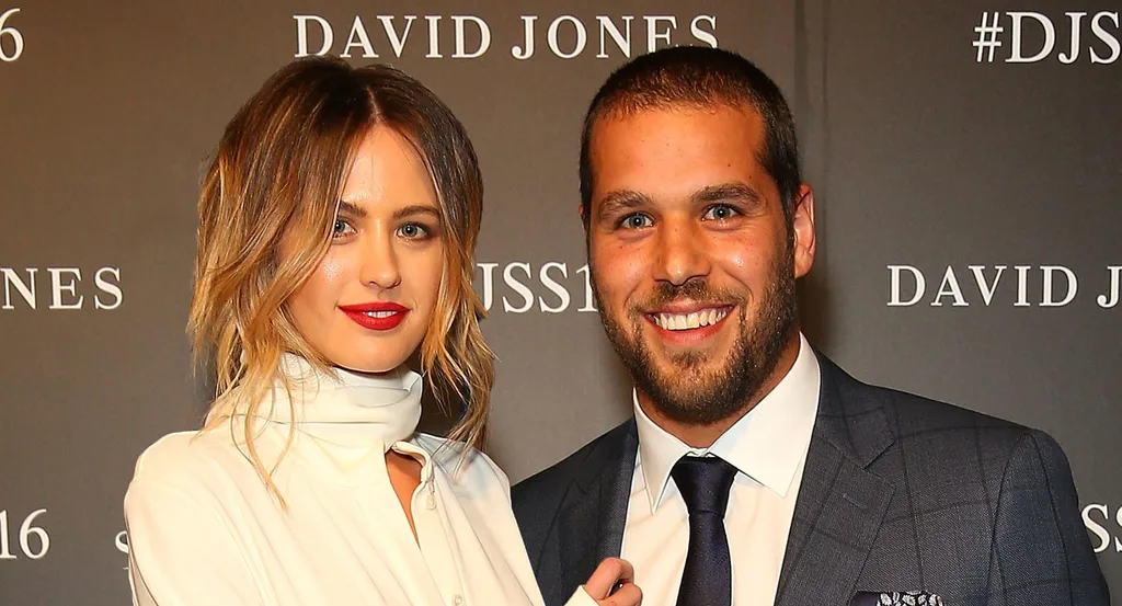 Two people smiling at a David Jones event, wearing formal attire.