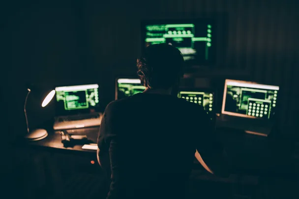 Man on multiple screens in the dark