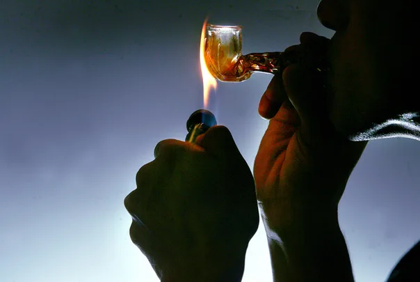 A man smoking a Meth Drug Pipe