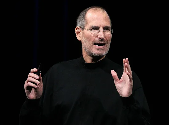 Steve Jobs wearing a black shirt while presenting a new product launch on stage