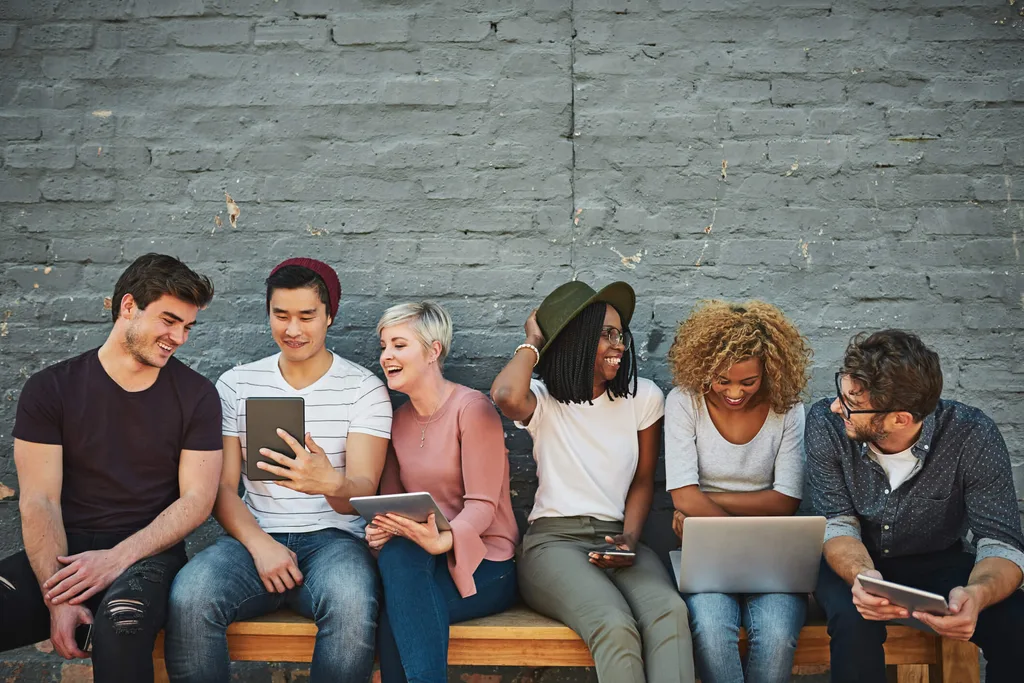 A group of friends sitting on a wooden bench