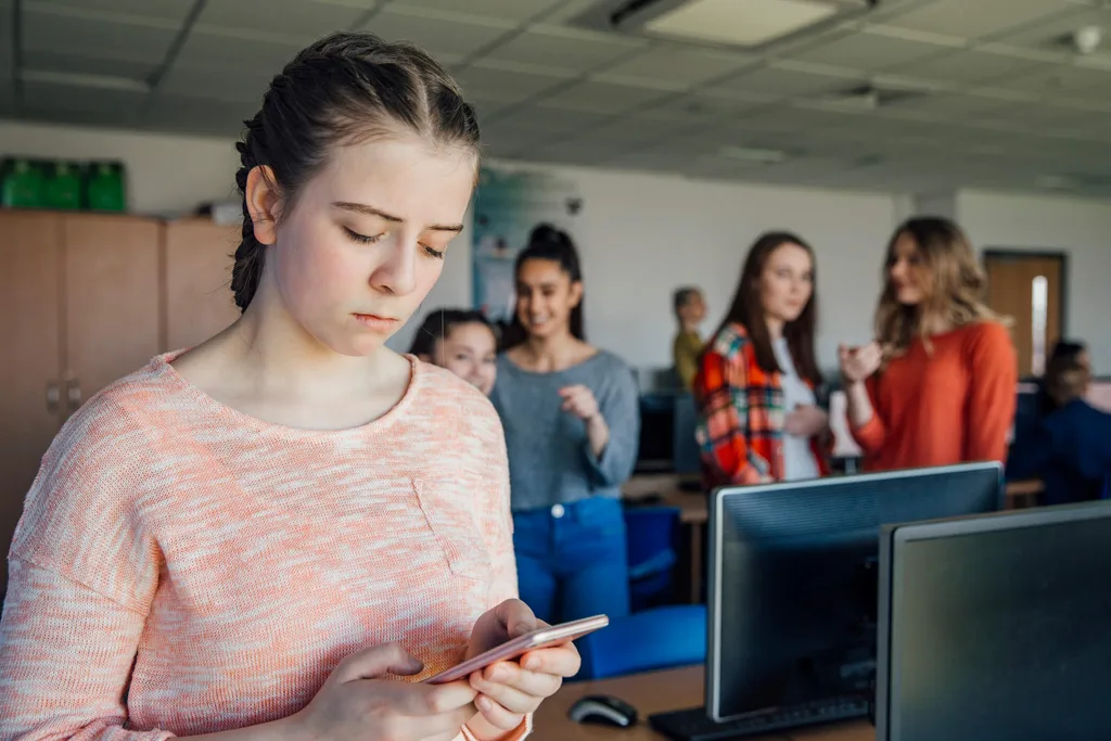 A girl getting bullied via text by another group of girls