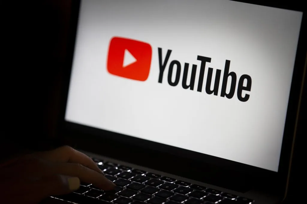 A laptop showing the YouTube logo on the screen