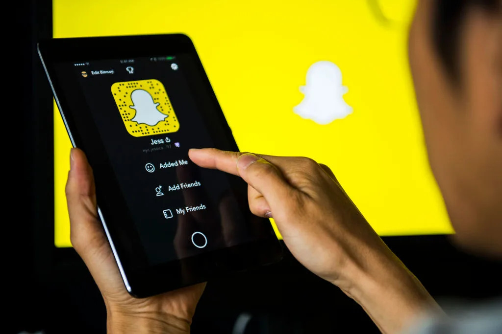 A man using the SnapChat app on his tablet