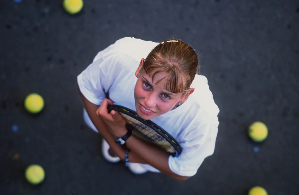 An aerial photo of Jelena Dokic looking up at the camera while holding a tennis racquet