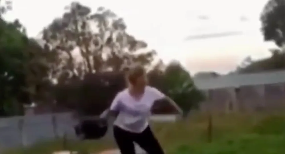 Woman throws cat across yard
