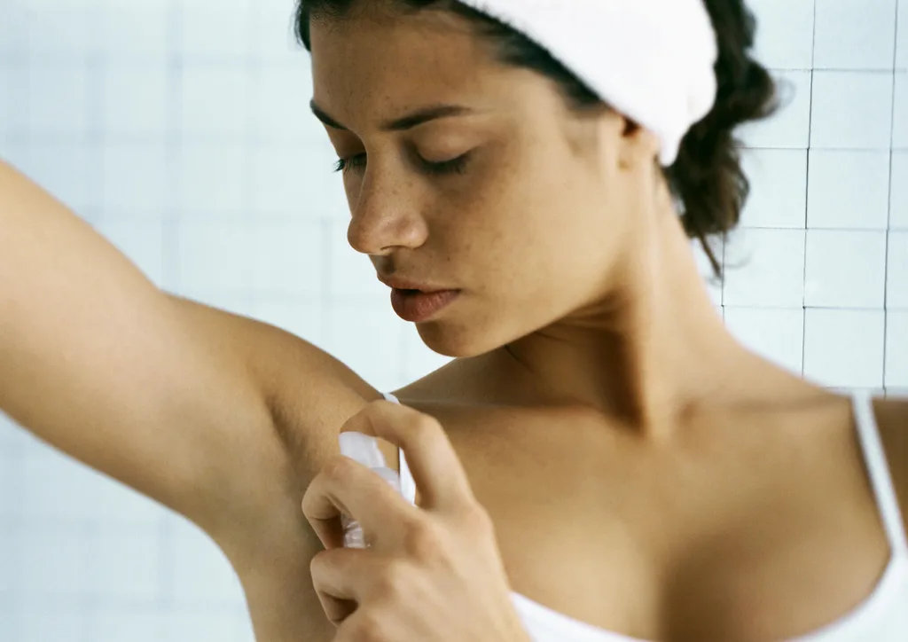 A woman applying underarm perfume
