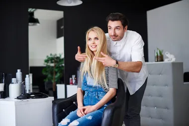 A male hairdresser showing a woman a hair cut length