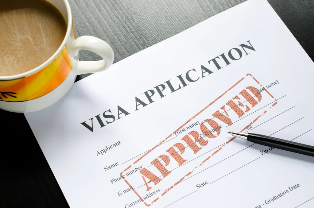 A Visa Application with a cup of coffee and a pen